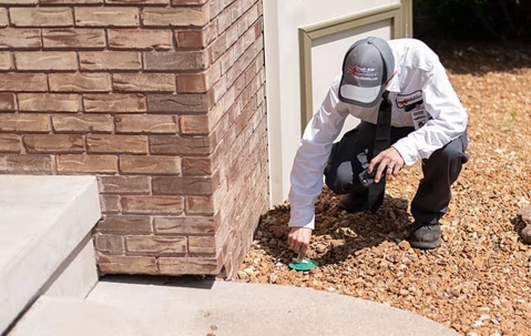 Professional Pest Control Technician installing termite control equipment.